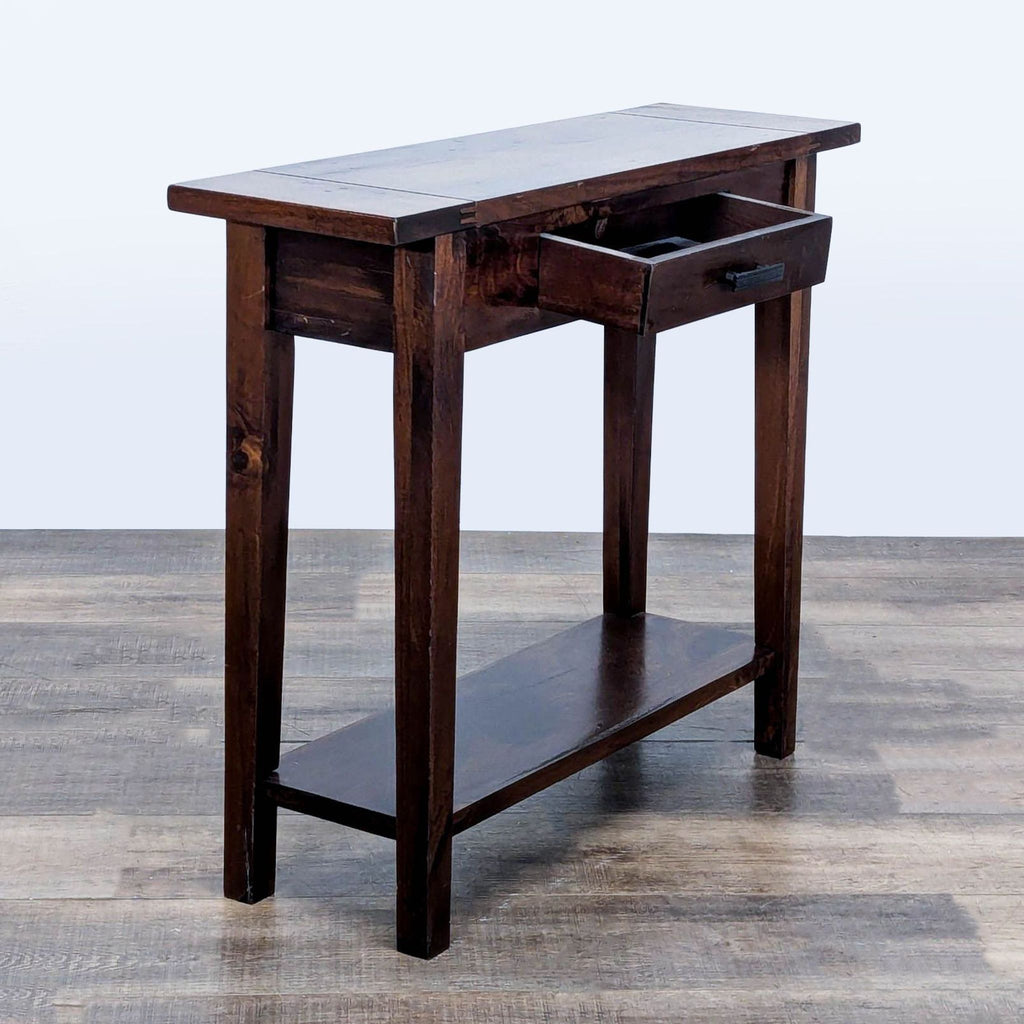 2. Angled view of a dark wood console table by Cost Plus World Market, displaying open drawer and bottom shelf.