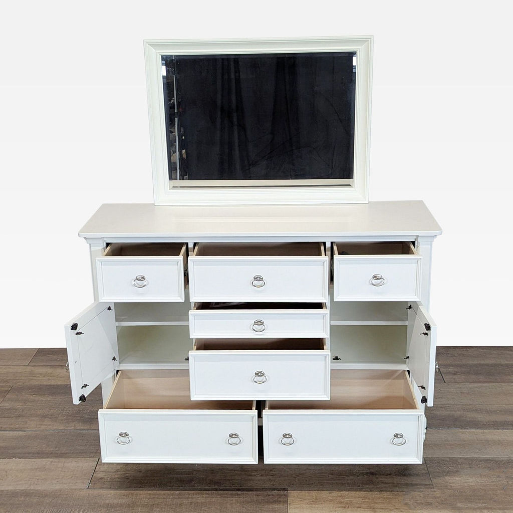 2. Ashley white dresser with all seven drawers and two frosted glass cabinet doors open, plus a large mirror.