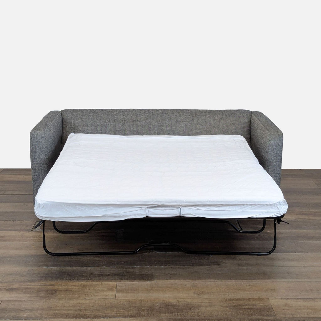 2. CB2 sleeper sofa with its pull-out bed extended, revealing a 5.25" coil/foam mattress.