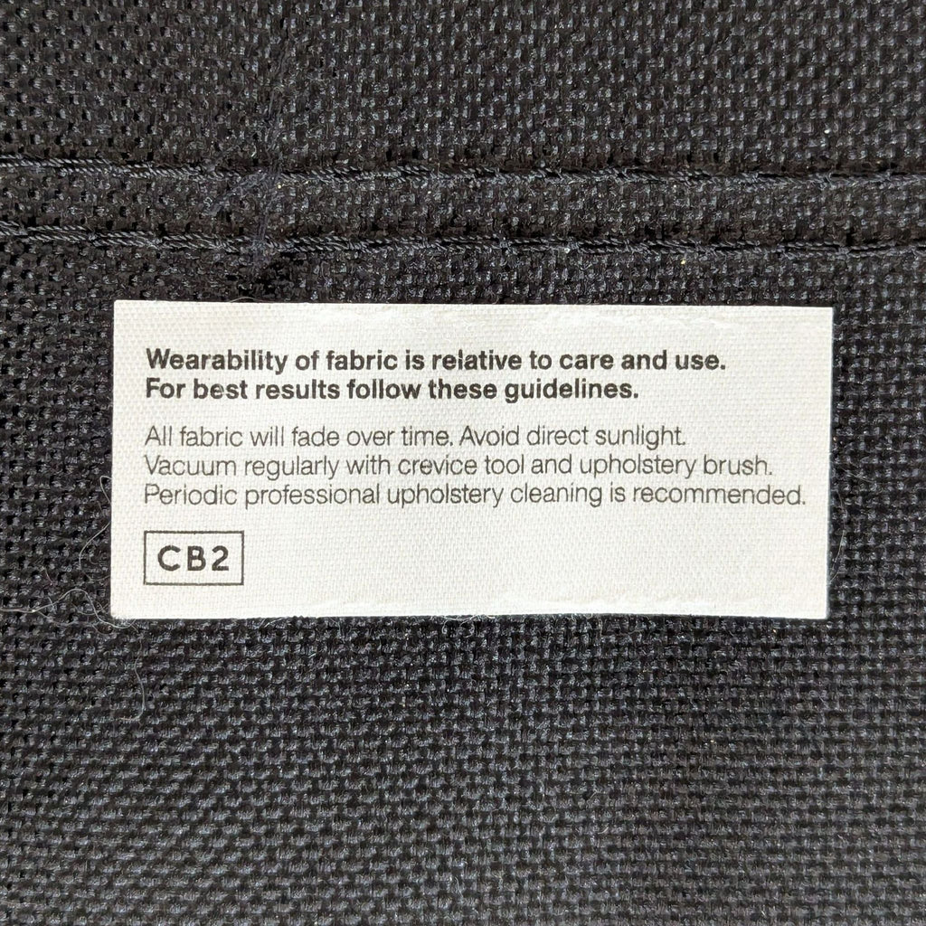 3. Close-up of the CB2 sofa care label with fabric cleaning and maintenance instructions.
