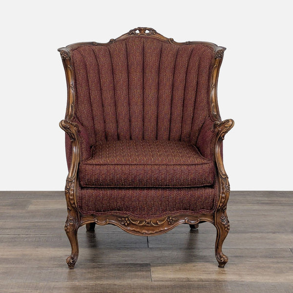 Front view of a Reperch lounge chair with a carved wooden frame and vertically tufted, flared backrest.