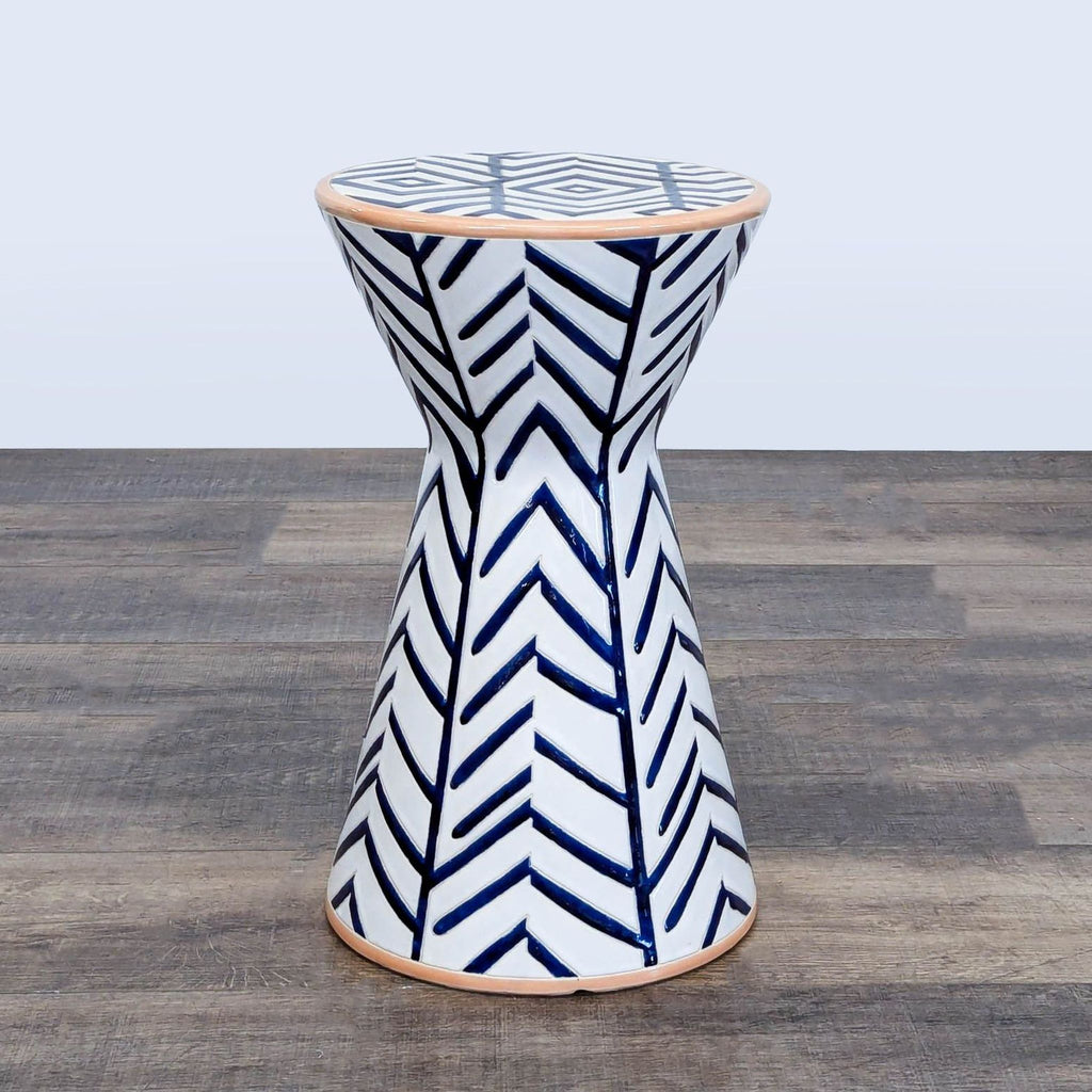 1. Anthropologie end table with blue and white geometric chevron pattern on a flared hourglass ceramic base.