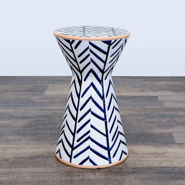 1. Anthropologie end table with blue and white geometric chevron pattern on a flared hourglass ceramic base.