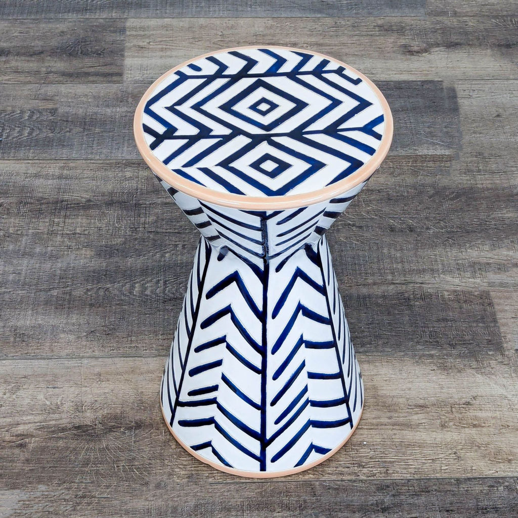 3. Hourglass-shaped Anthropologie end table with striking navy chevron design on glossy white ceramic.
