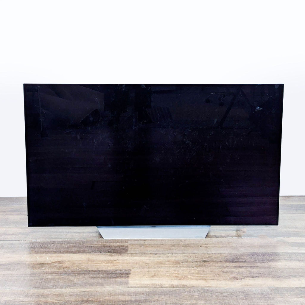 Front view of an LG 55-inch 4K Ultra HD Smart TV with a slim modern design and stable stand.  