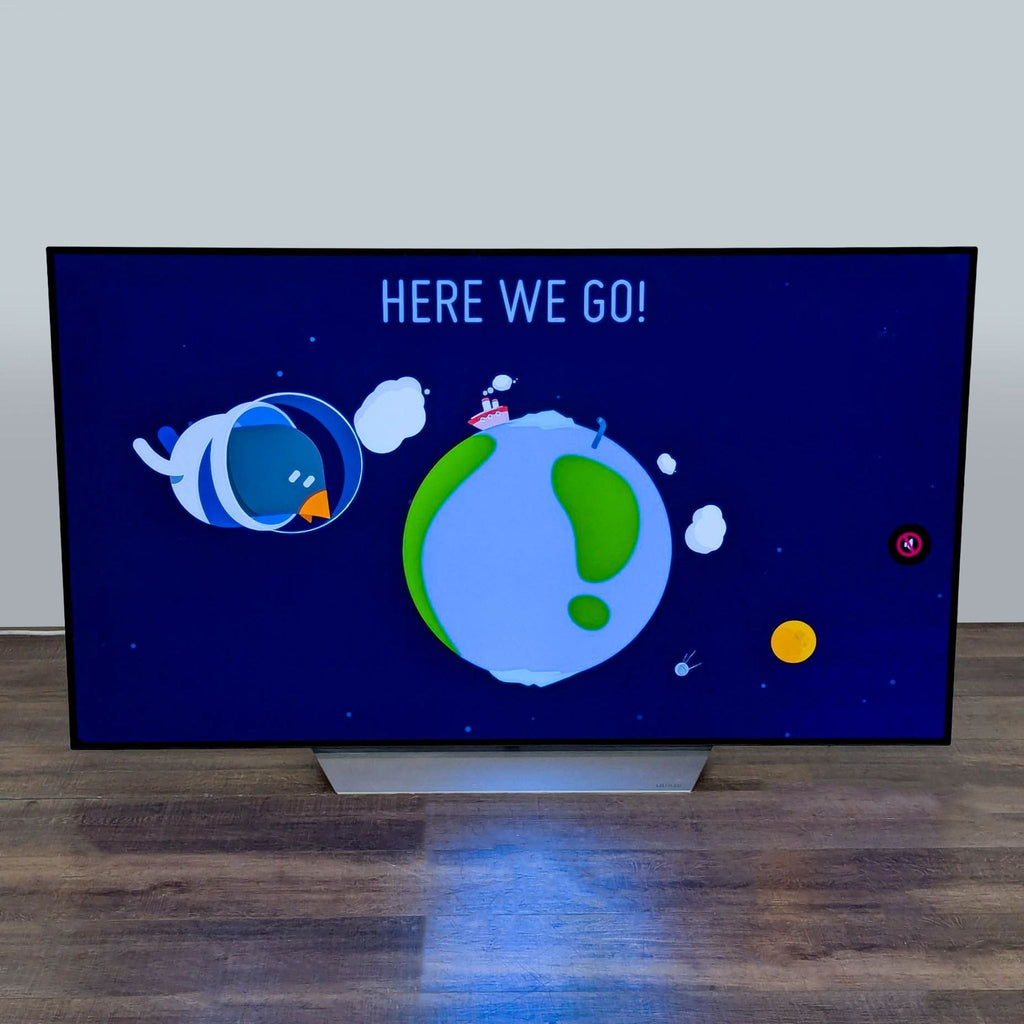LG 55-inch 4K Ultra HD Smart TV displaying a colorful screen with cartoon graphics and "Here We Go!" text.  