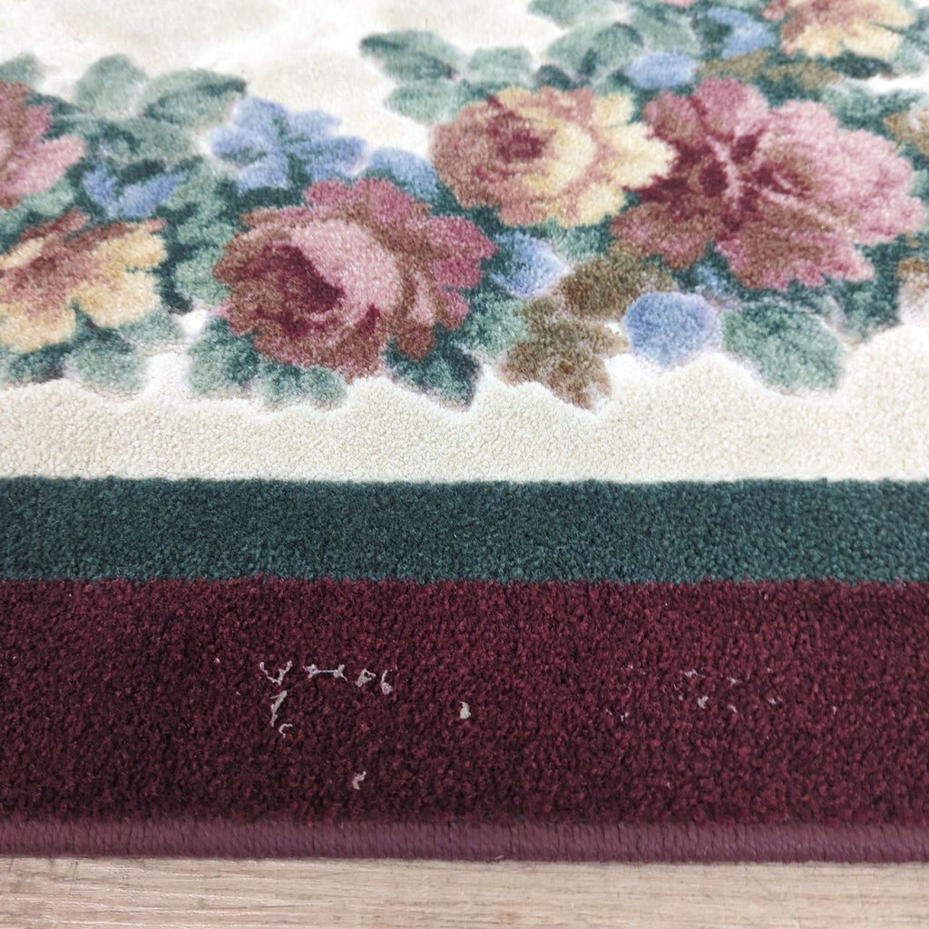 3. Zoomed view of Reperch rug’s maroon border and floral design, highlighting minor wear and hand-carved effect.