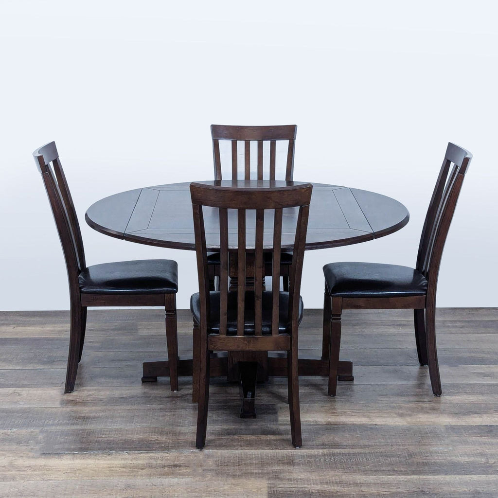 1. Dark wood round dining table with four drop leafs and four slat back chairs with black leather seats.  