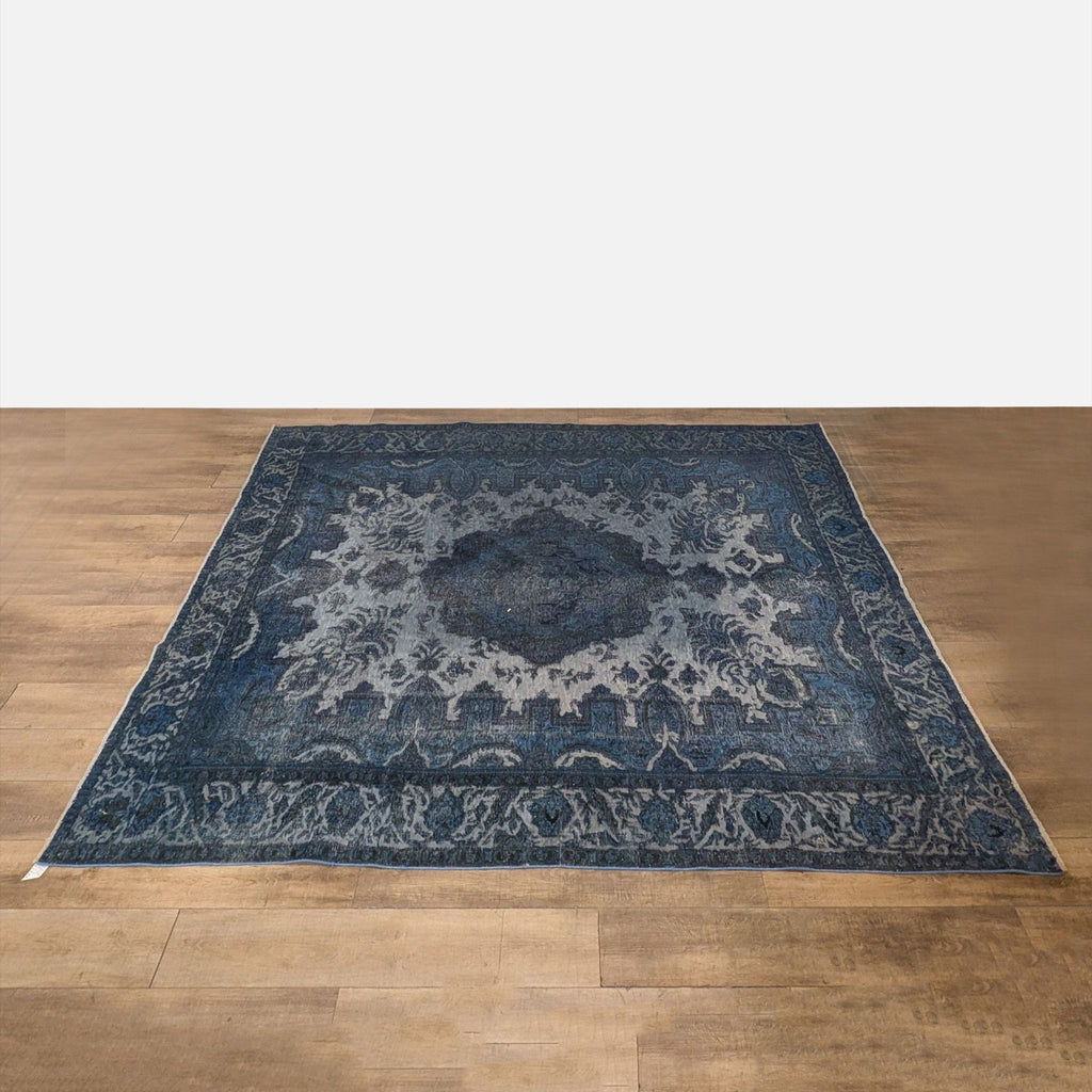 1. Overhead view of a large, hand knotted, vintage over dyed blue wool Reperch rug on wooden floor.