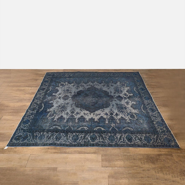 1. Overhead view of a large, hand knotted, vintage over dyed blue wool Reperch rug on wooden floor.