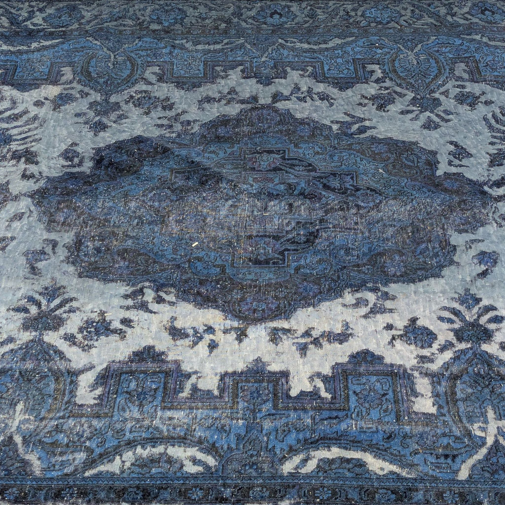 2. Close-up of the intricate blue and gray pattern on a vintage hand knotted Reperch wool area rug.
