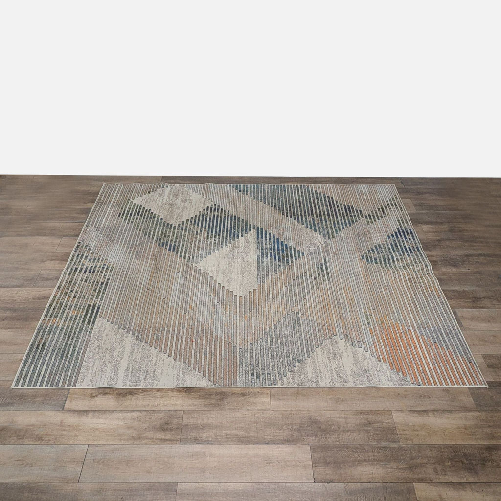 1. Geometric patterned nuLOOM rug in neutral and blue tones, machine made from polypropylene, shown on wood floor.