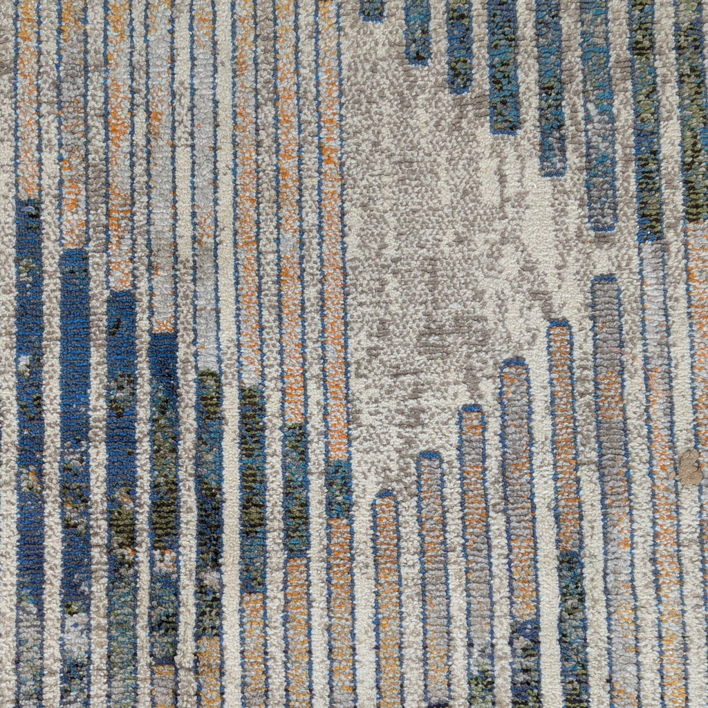 2. Close-up of nuLOOM rug showing linear geometric design with blue, orange, and beige polypropylene fibers.