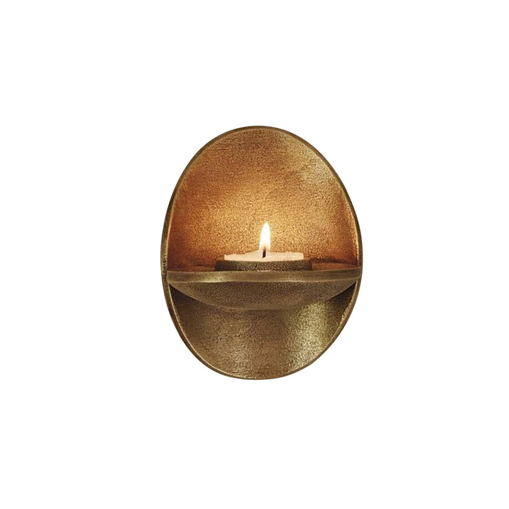 Lit bronze tea light holder from Ferm Living, oval-shaped and made with recycled cast aluminum.