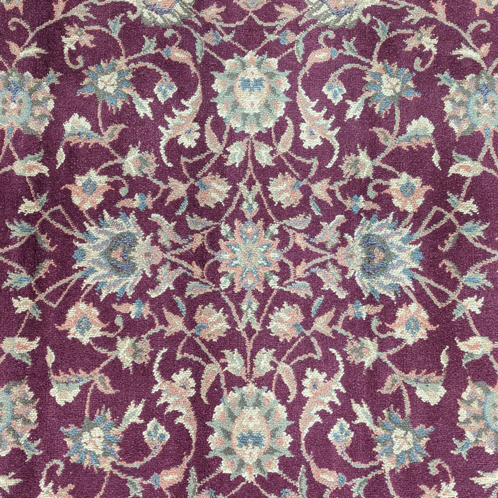 2. Close-up of Reperch area rug showing detailed floral motifs in cream and blue on a red background.