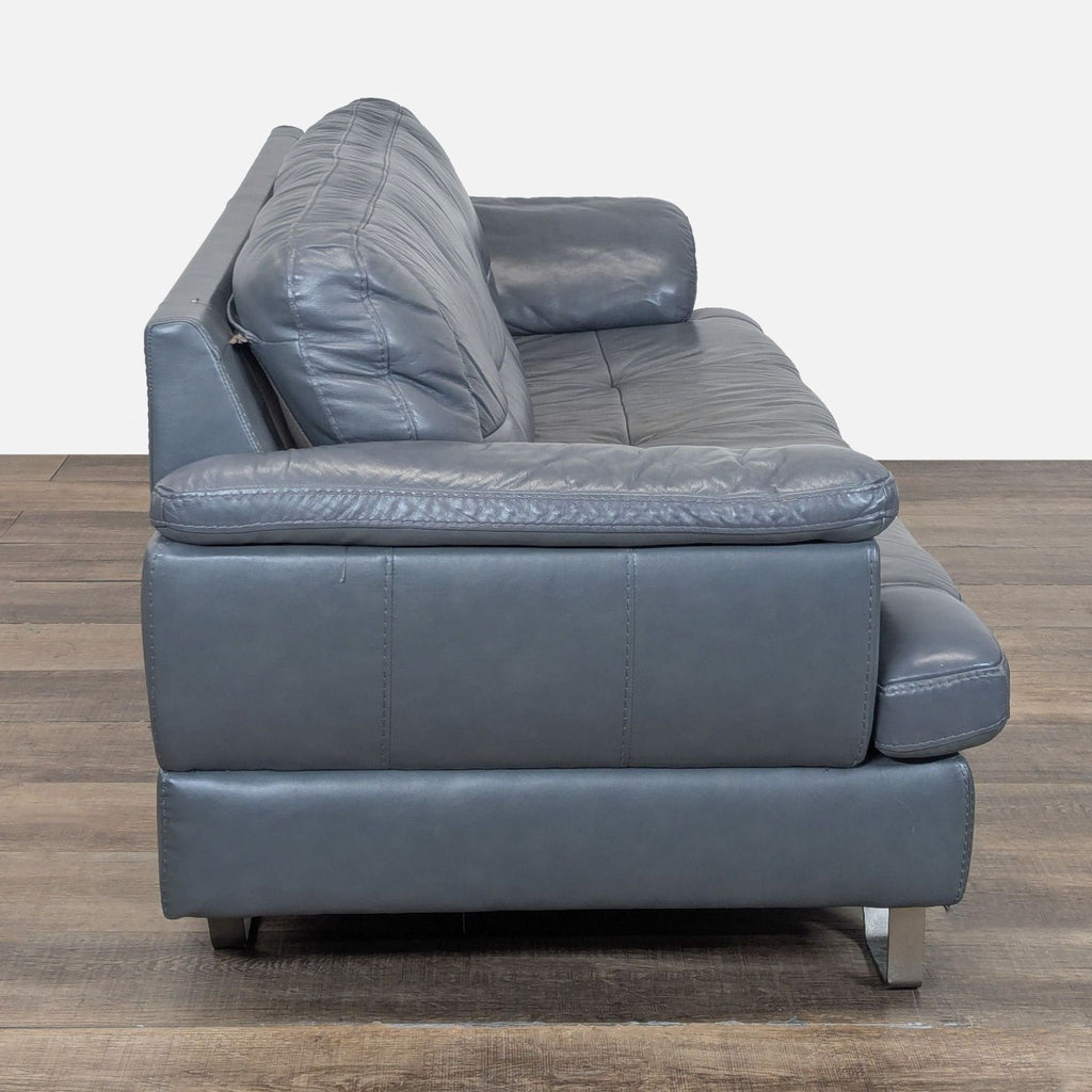 Side profile showing the Ashley Furniture 3-seat sofa's thick leather upholstery, soft armrests, and sleek metal legs.  