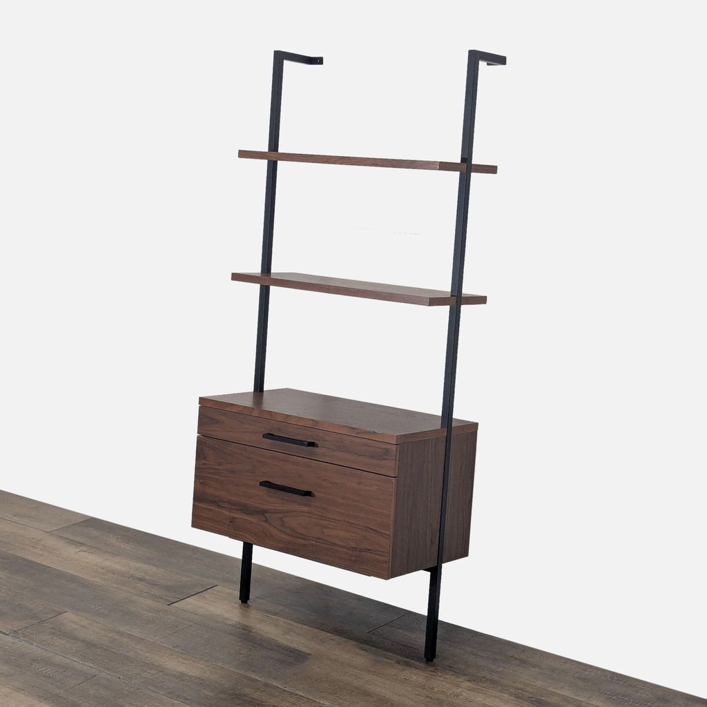 2. Angled view of the CB2 walnut veneer bookshelf, showing black metal frame and two spacious drawers.