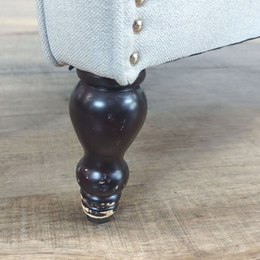 3. Close-up of the wooden leg and nailhead trim detail on Willa Arlo Interiors lounge chair.
