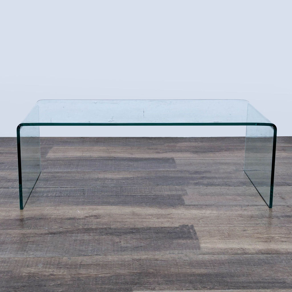 Sleek Ivy Bronx coffee table made entirely of transparent glass, showcasing smooth, curved edges.