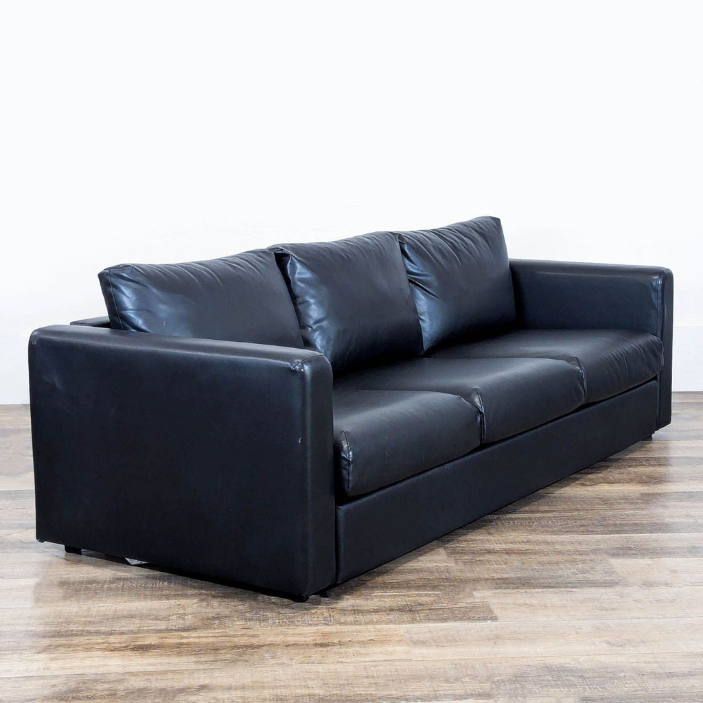 3. Angled view of an Ikea 3-seat sofa with black leather upholstery and deep, comfortable cushions.