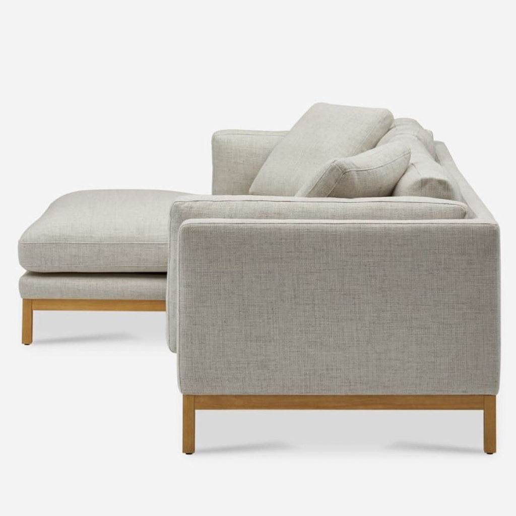2. Side profile of a Castlery sectional, featuring a wood base and plush cushions with a right-side chaise.