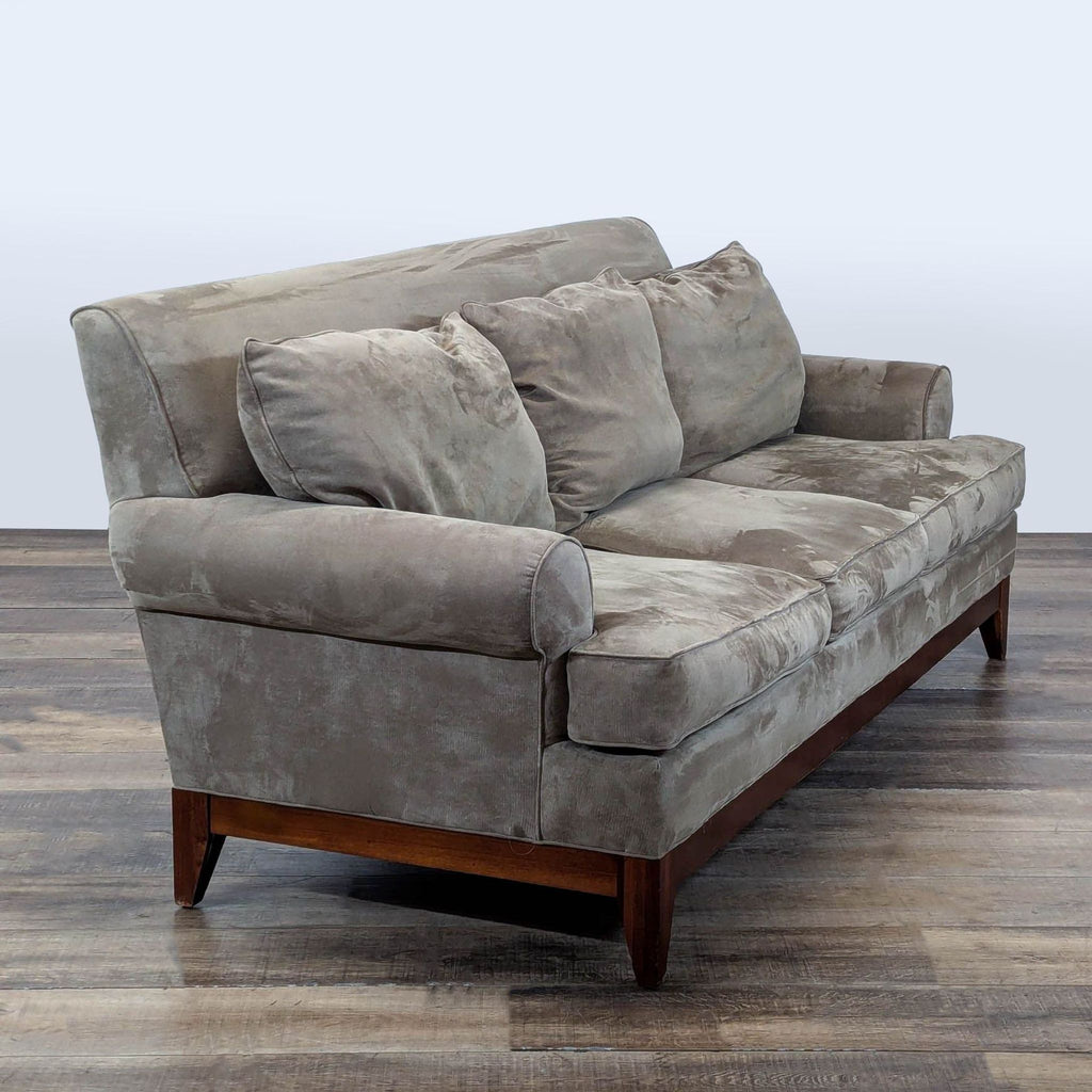 3. Angled view of a gray Kincaid 3-seat sofa highlighting rolled arms, welted trim, and a wood base.