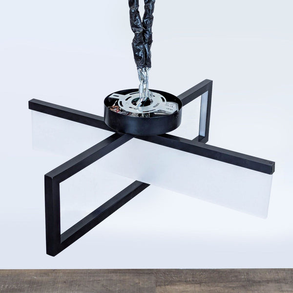 1. Modern black cross-shaped pendant light by Reperch, featuring frosted white panels and suspended by a chain.  