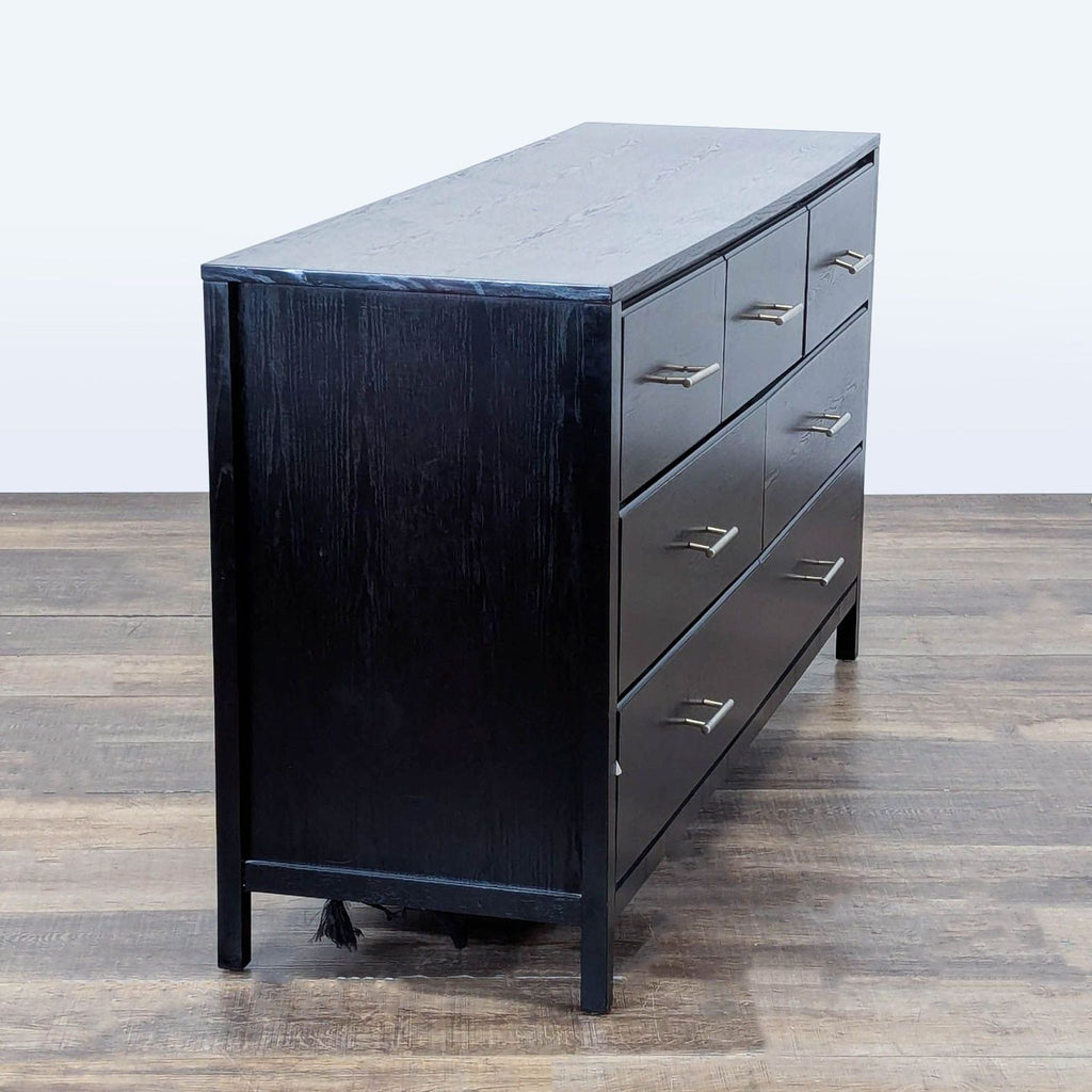 3. Modern black dresser from New Classic Furniture, side perspective with brushed nickel handle accents.