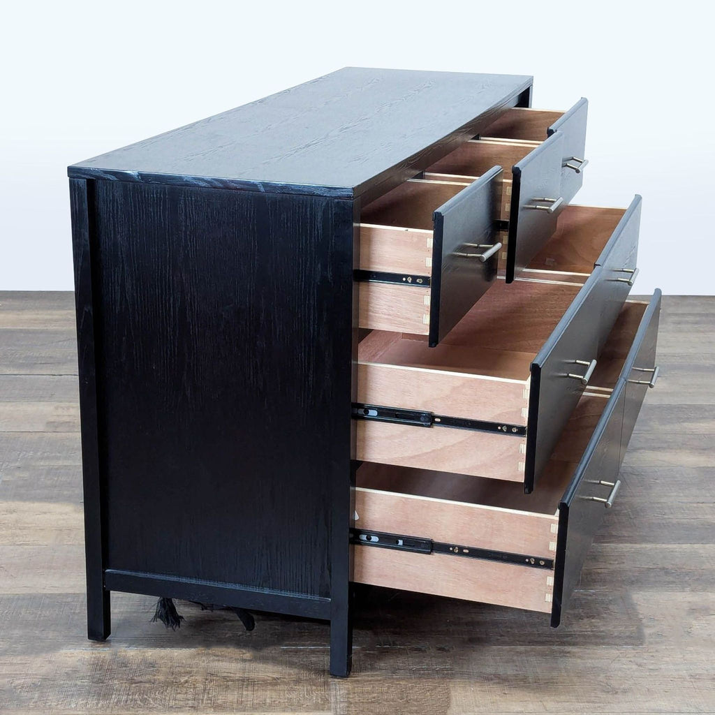 2. Side angle of the black dresser showing 7 drawers on metal glides, partially open, modern handles.