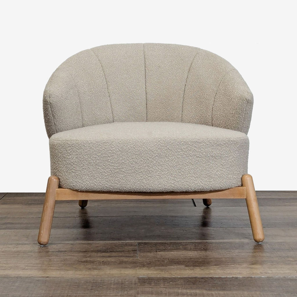 1. Front view of an AllModern lounge chair with boucle upholstery and wood base, on a wooden floor.