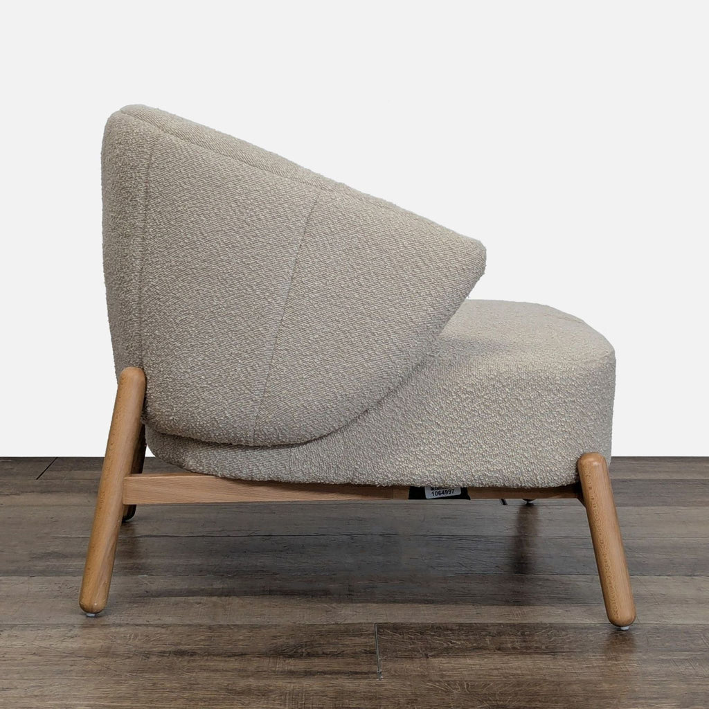 2. Side view of boucle upholstered lounge chair from AllModern, showing angled wood legs and curved back.
