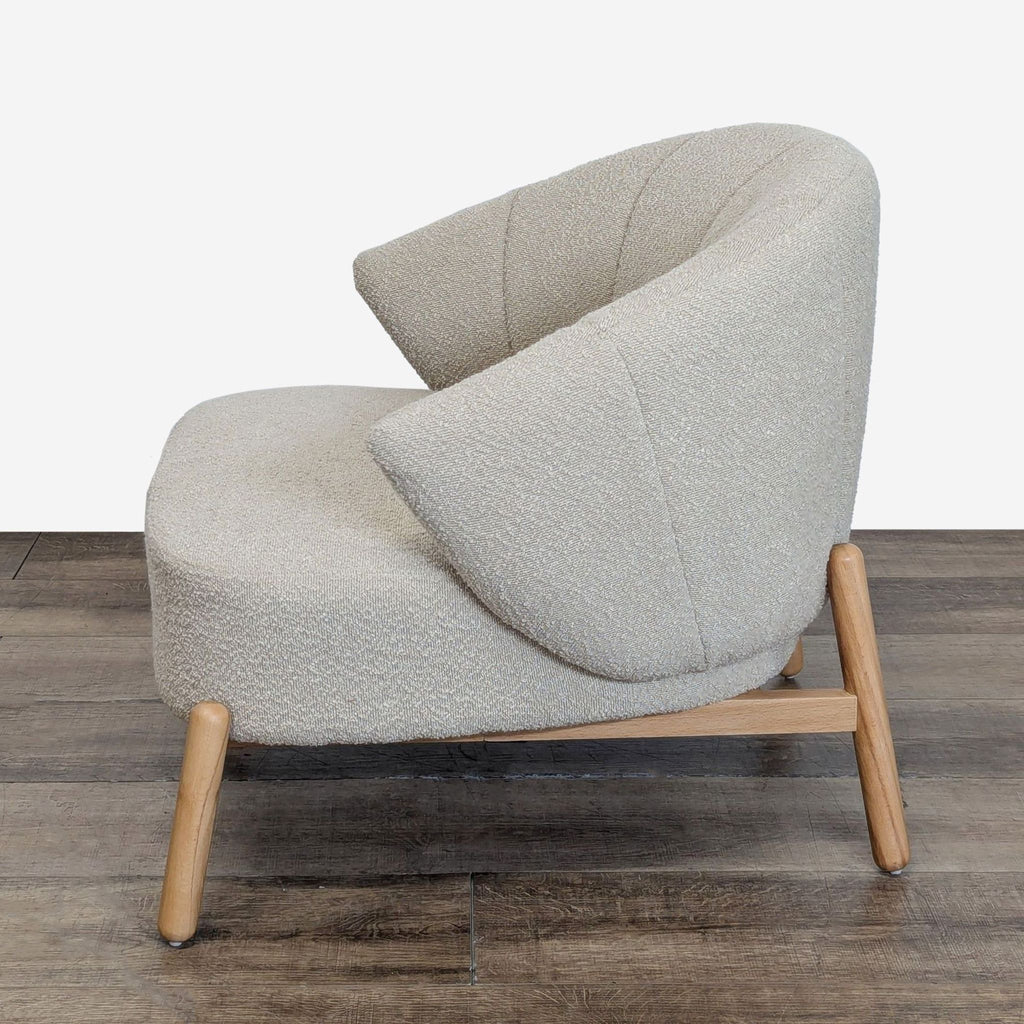 3. Angled side perspective of AllModern lounge chair, featuring textured boucle fabric and wooden frame.