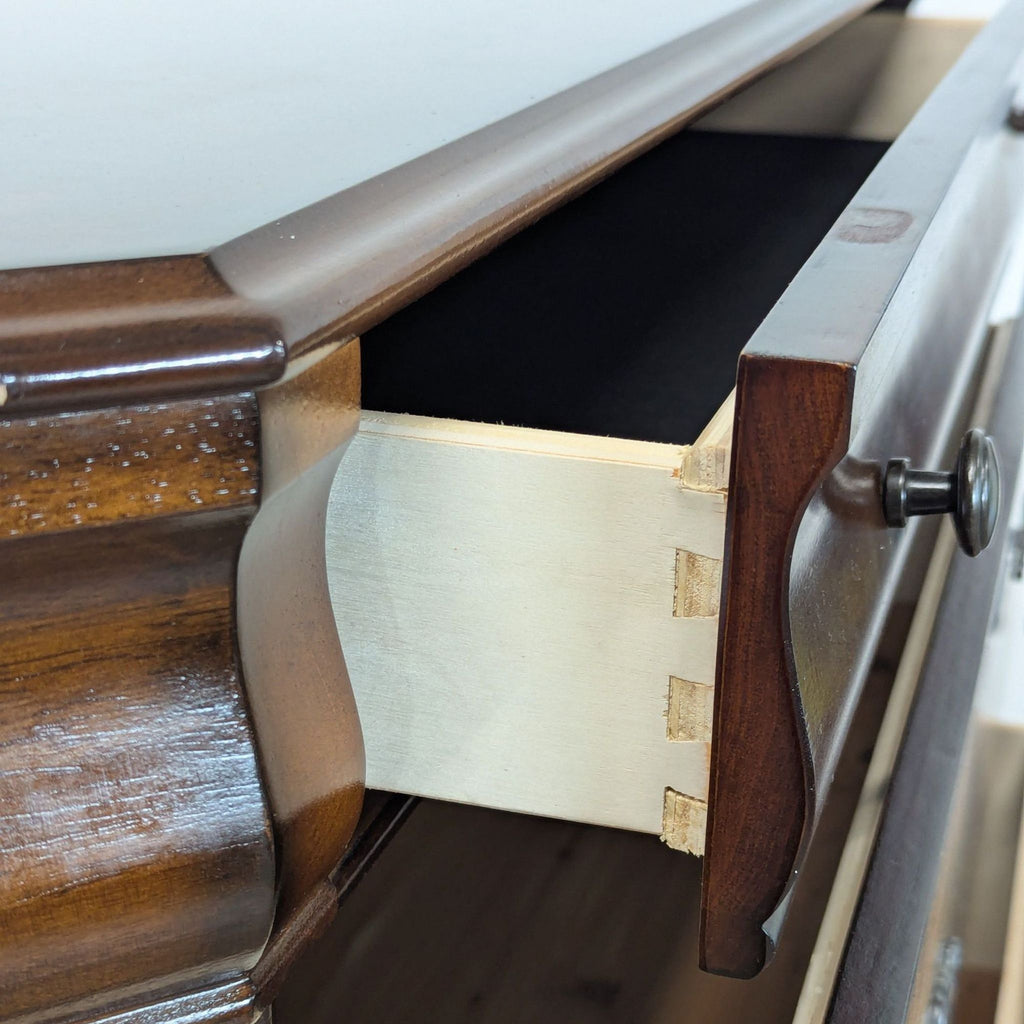 3. Close-up view of Ashley dresser’s dovetail drawer construction and detailed wood grain with bronze knob.