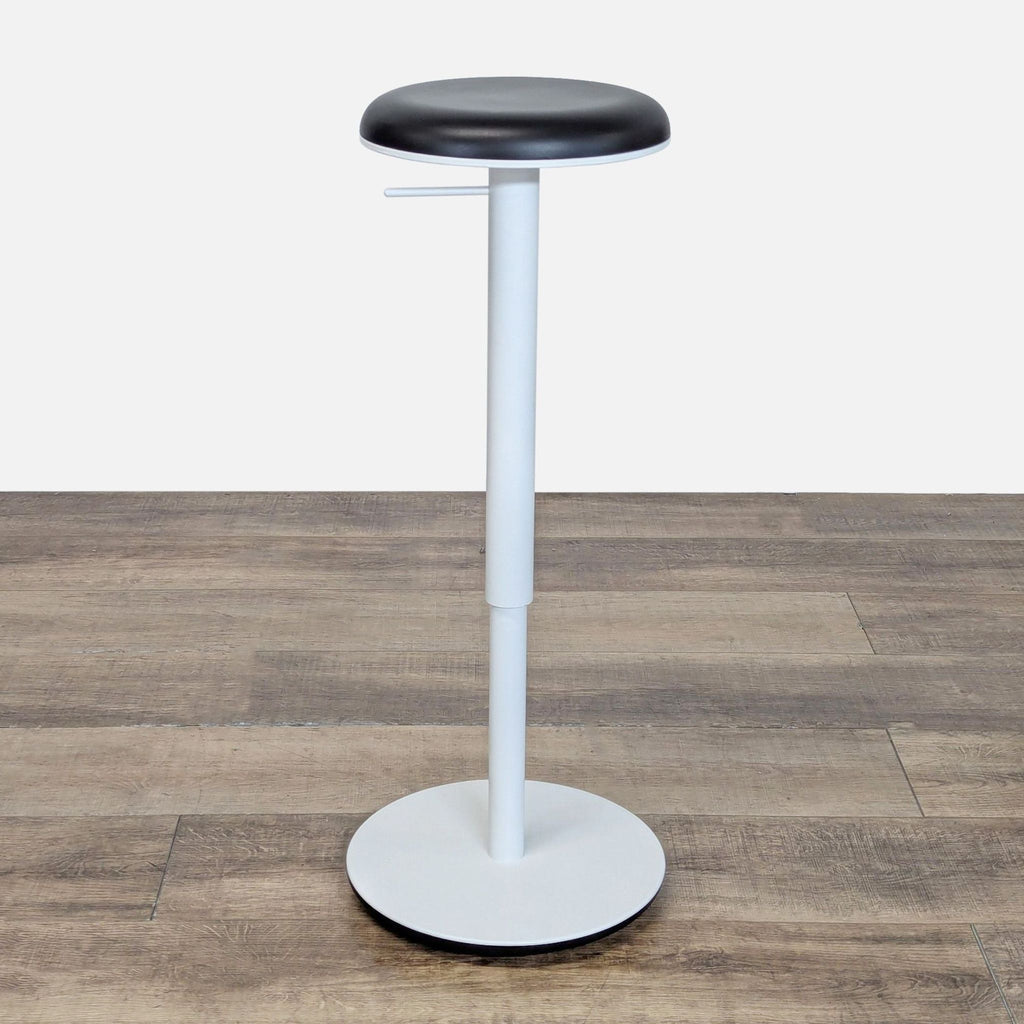 1. Modern black and white Tilt Stool by Haworth with height-adjustable steel column and rounded tilting base.