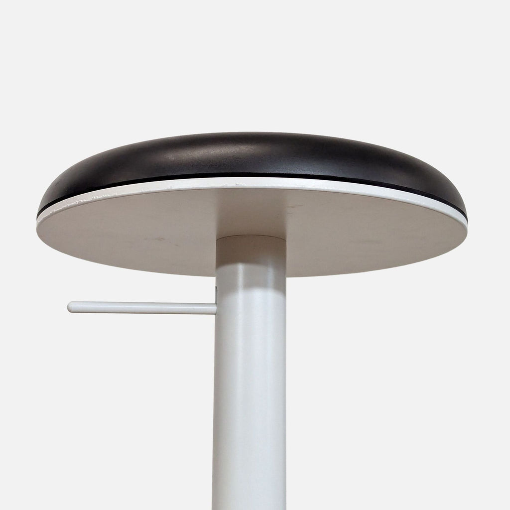 2. Close-up side view of the stool’s round black urethane seat and pneumatic adjustment handle by Haworth.