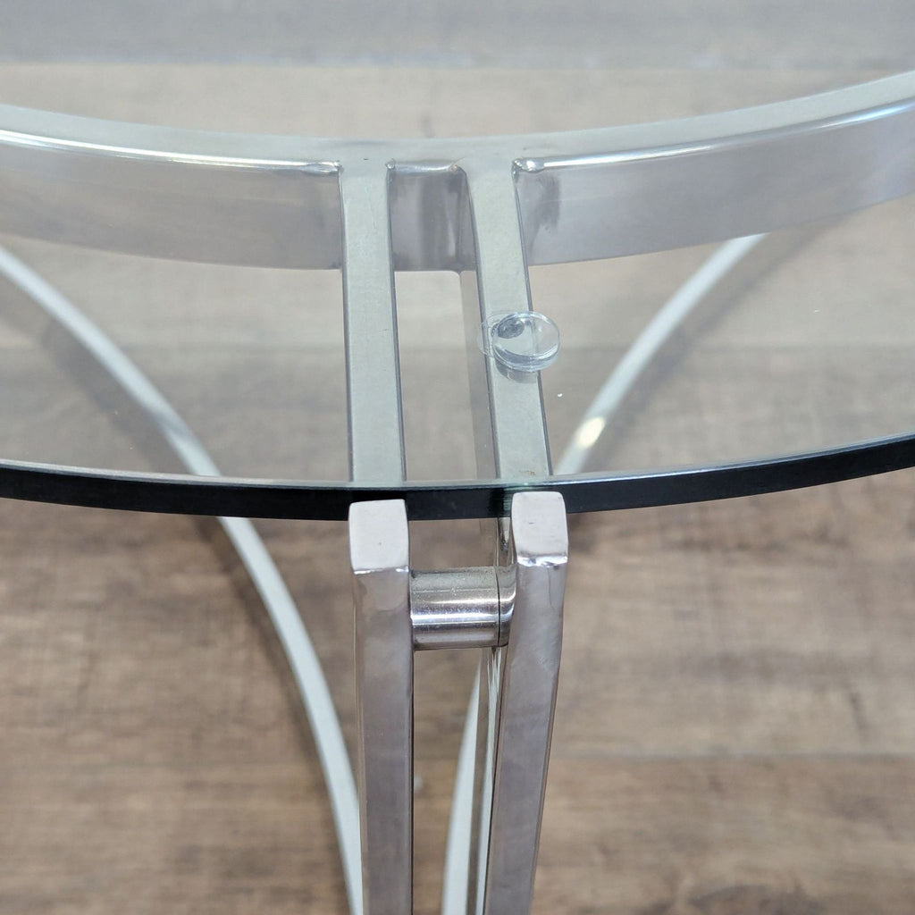 3. Close-up of the chrome frame and glass top connection on the Reperch Coffee Table.
