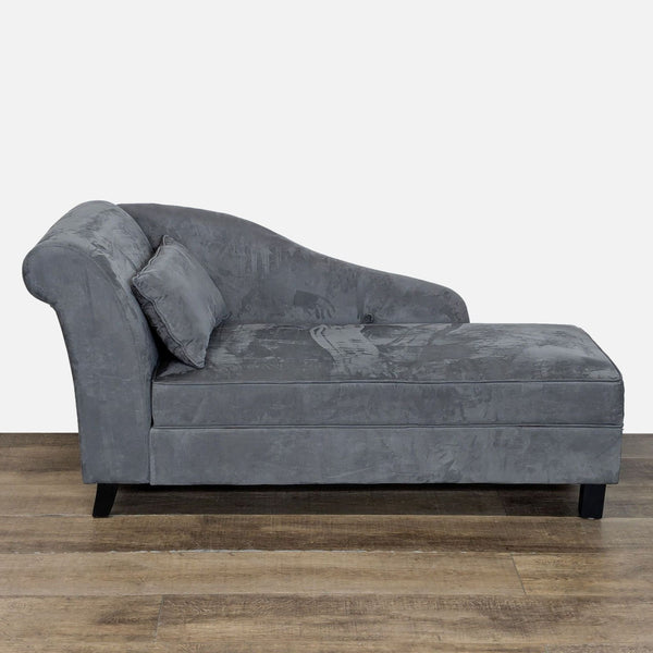 Grey microfiber chaise lounge by Reperch, featuring storage space and wood legs, shown from the side.  
