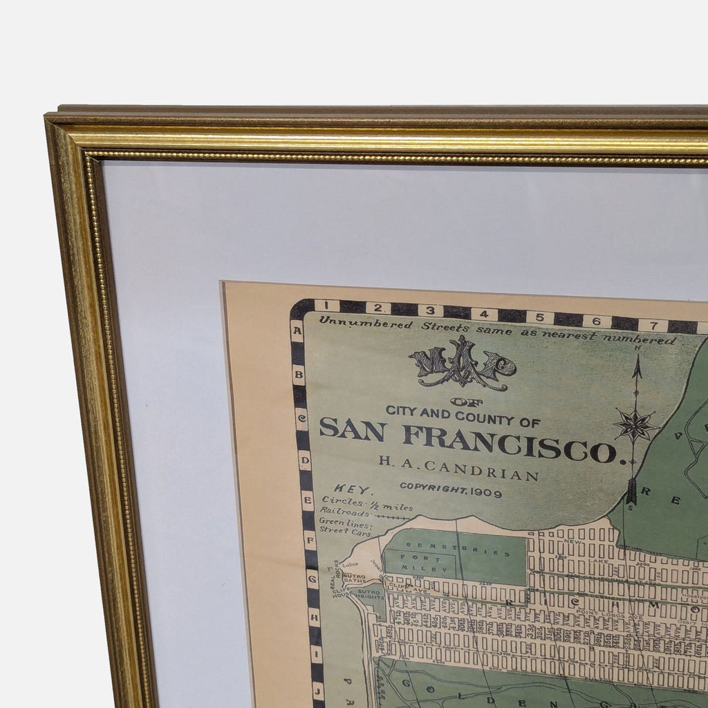 3. Corner detail of a framed reproduction 1909 San Francisco city map, highlighting the title and gold frame.