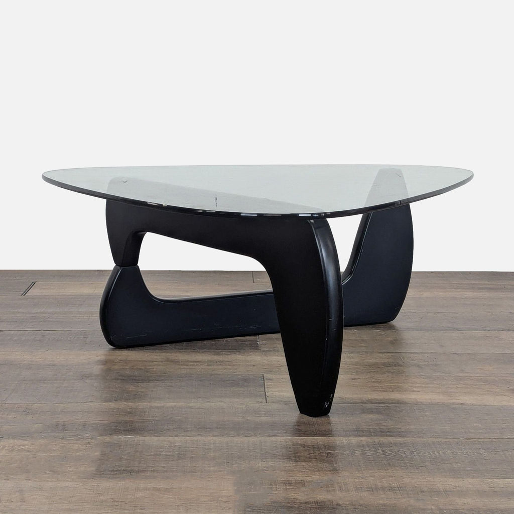 2. Side view of Reperch Noguchi coffee table, showing sculpted black wood base and curved glass surface.