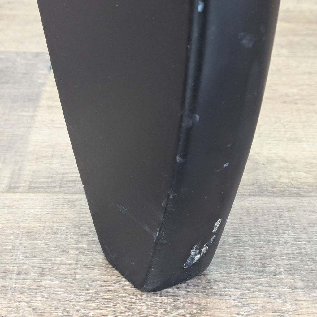 3. Close-up of the Reperch Noguchi coffee table’s black wood base showing slight surface wear.