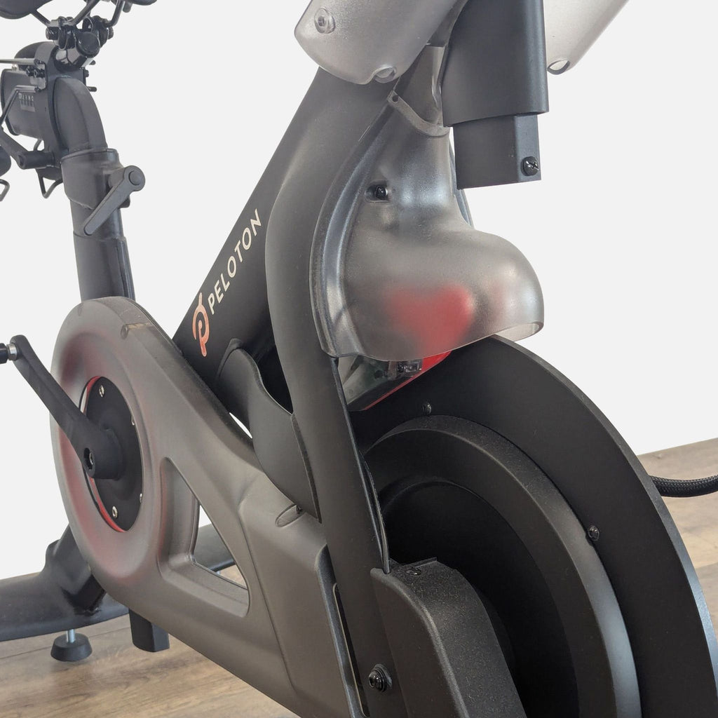 3. Close-up of a Peloton exercise bike’s frame and flywheel, highlighting its robust construction and modern design.