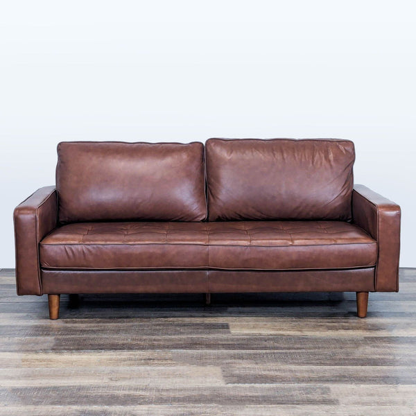 Abbyson 3-seat sofa with genuine tufted leather upholstery and wood feet, shown from the front.  