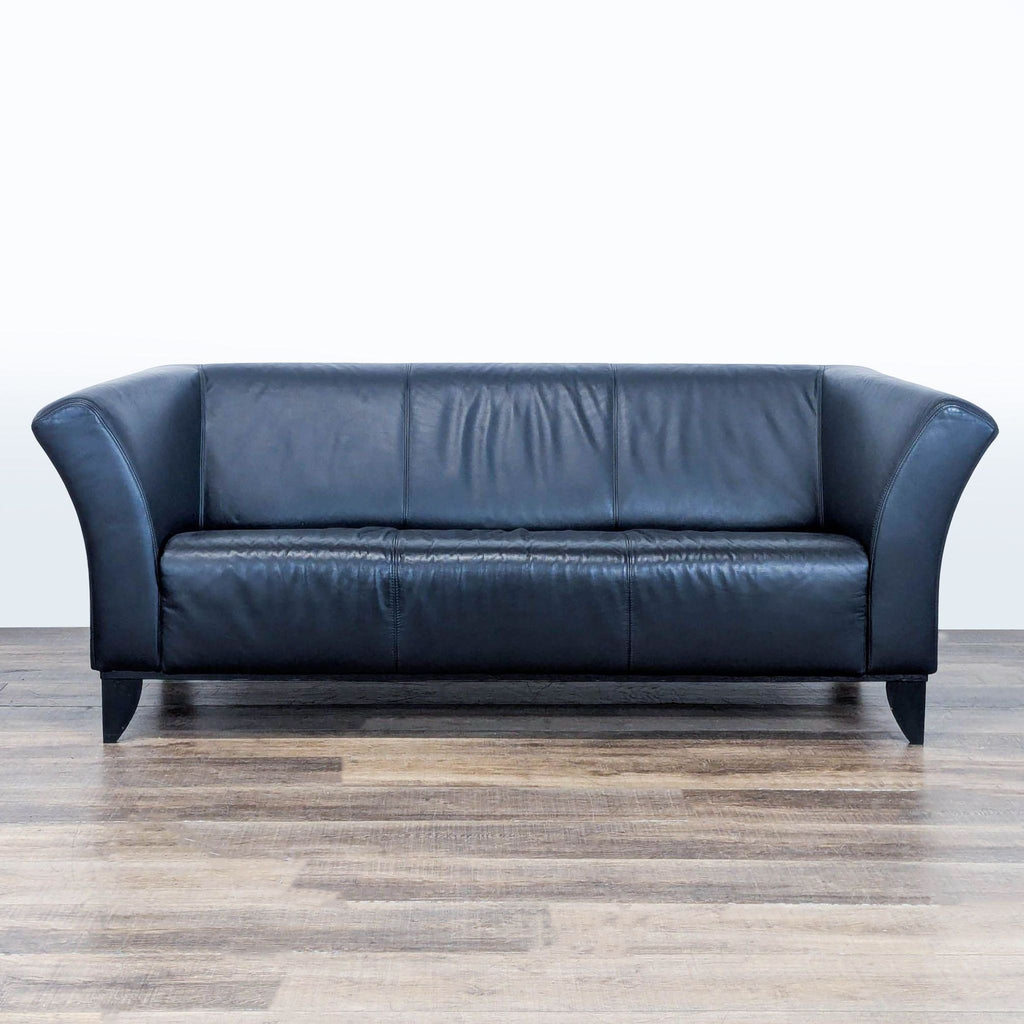 1. Black leather 3-seat IKEA sofa with flared arms and wood tapered feet, shown from the front on wood floor.  