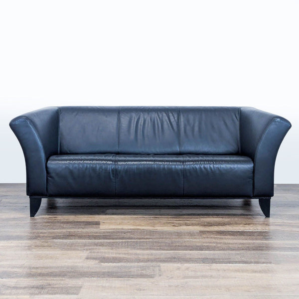 1. Black leather 3-seat IKEA sofa with flared arms and wood tapered feet, shown from the front on wood floor.  
