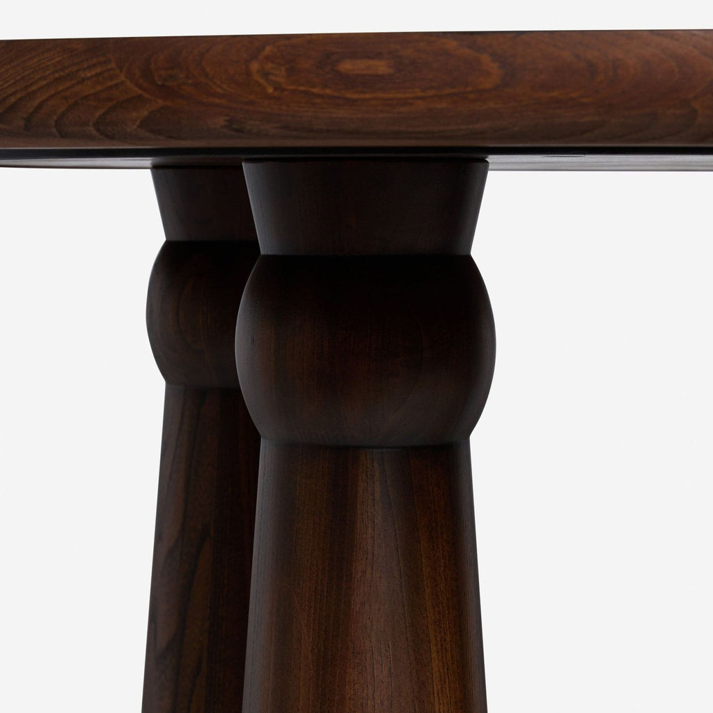 Close-up of Lulu And Georgia dining table legs, showing rounded tops and rich cocoa Sungkai wood grain.  
