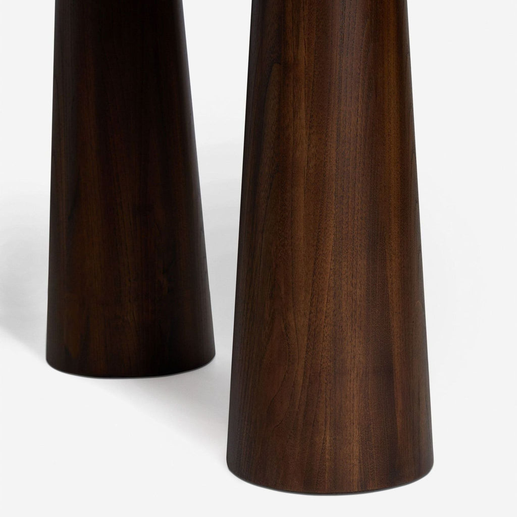 Detail of tapered removable legs on Lulu And Georgia Sungkai wood dining table with a smooth cocoa finish.