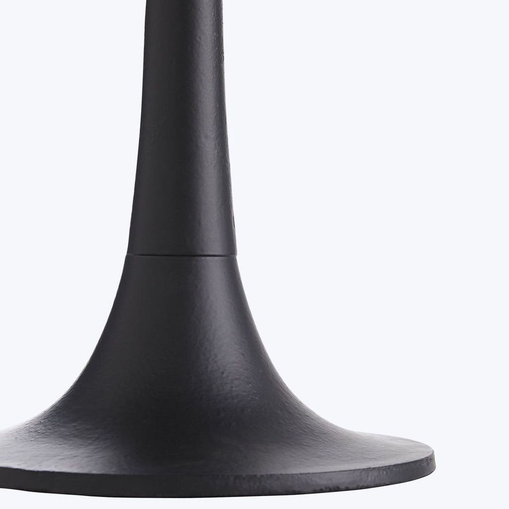 2. Close-up of the sturdy tulip-shaped black iron base from an Arteriors Home modern side table.