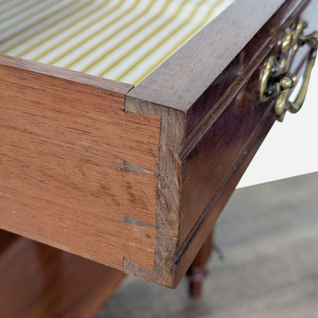 3. Close-up detail of the Reperch table drawer, highlighting dovetail joints, brass handle, and striped lining.  