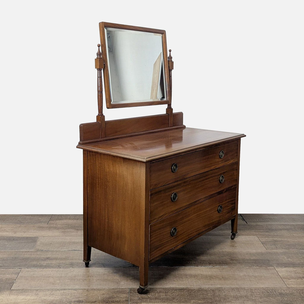 3. Angled view of Reperch dresser featuring three drawers, turned-post swing mirror, and small leg casters.