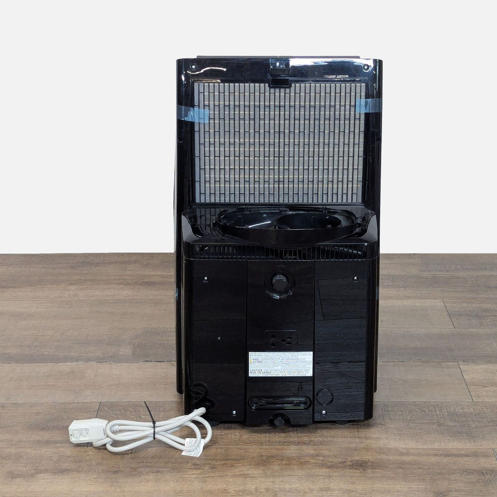 Rear view of a Midea Duo Smart portable AC, displaying the air filter panel and attached power cord.